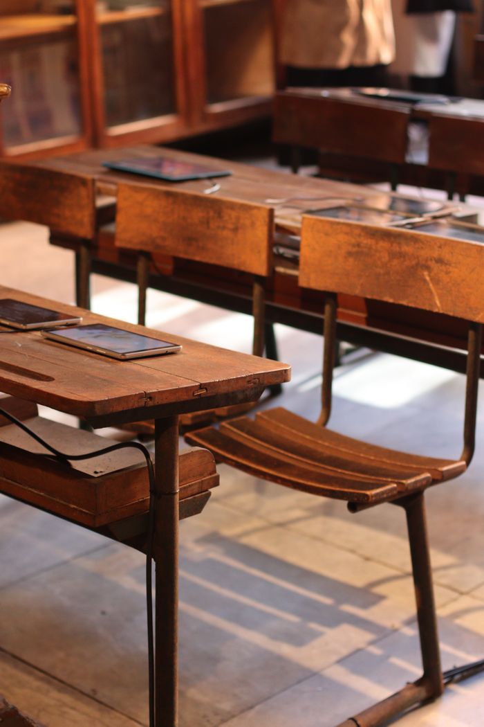 A blend of old wooden desks and modern tablets in an Istanbul classroom setting.